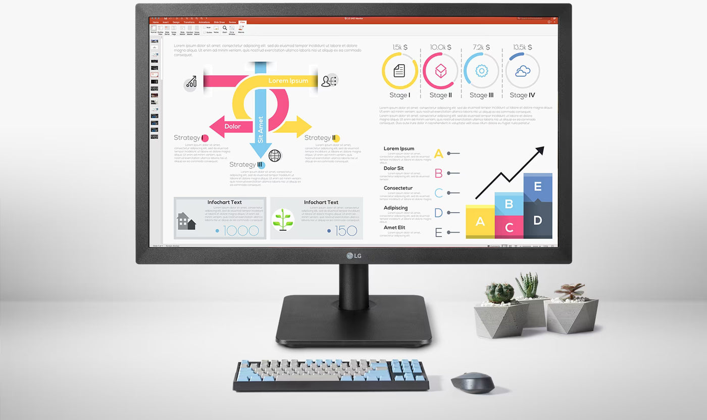 LG 27BK550Y-I monitor a kijelzőn üzleti diagramokkal. Művirágok, egér és billentyűzettel egy asztalon irodai környezetben.