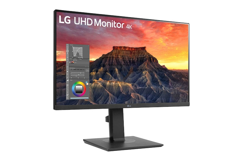 LG 27BQ65UB-B Monitor előlnézetben talpon, enyhén jobbra fordítva. A kijelzőn fotókalibrálás sziklás naplemente mintával.