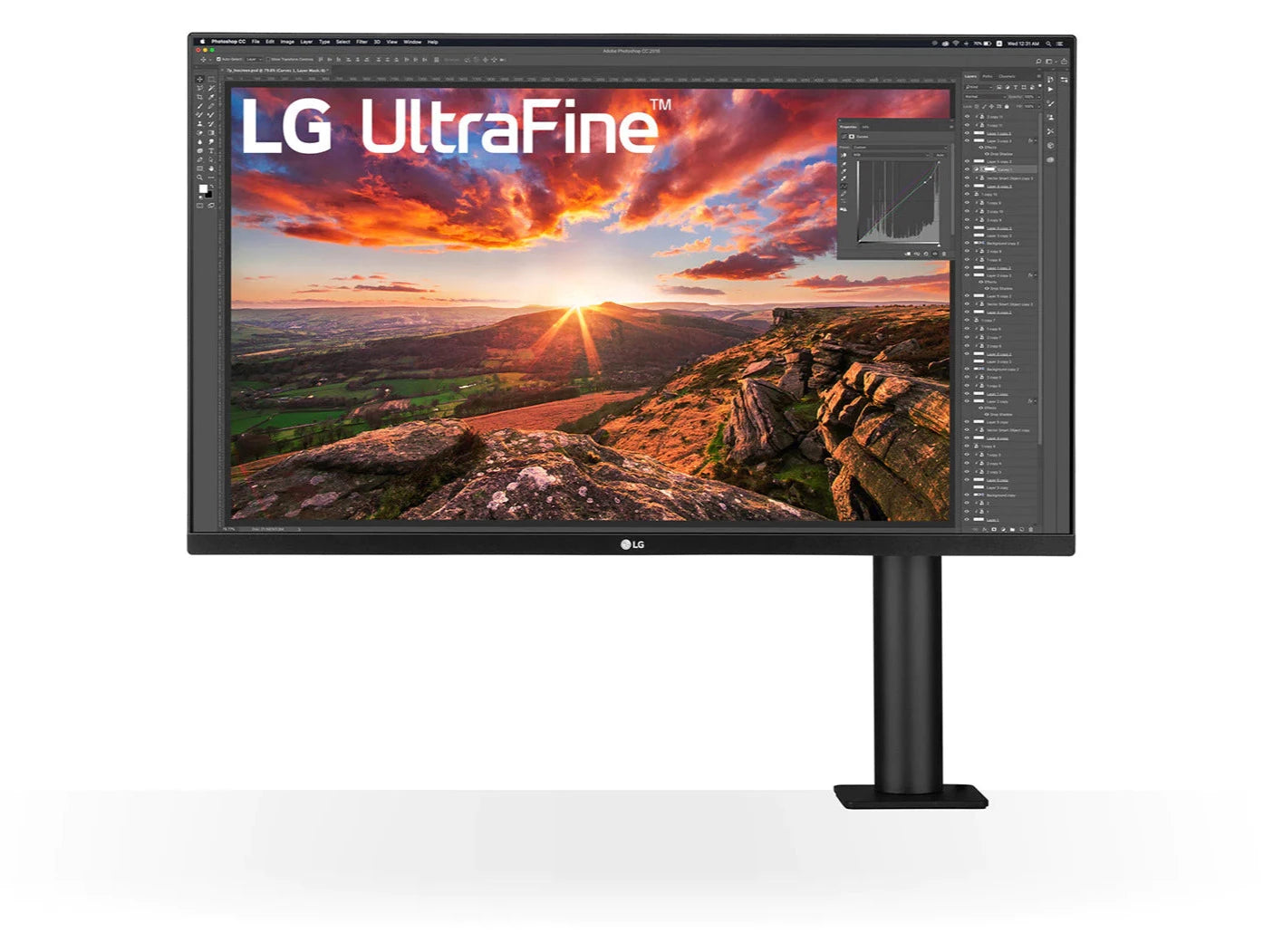 LG 27UN880P-B Monitor előlnézetben asztalra rögzítve. A kijelzőn naplemente egy hegyről nézve photoshopban megnyitva és lg ultrafine logó.