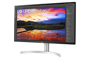 LG 32UN650-W Monitor előlnézetben enyhén balra fordítva, talpon. A kijelzőn egy farm tájképe photoshopban szerkesztve és lg uhd monitor logó.