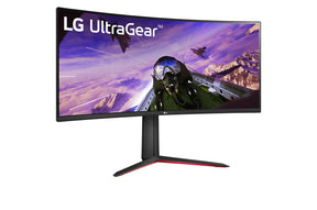 LG 34GP63AP-B UltraWide Monitor előlnézetben enyhén jobbra fordítva, talpon. A kijelzőn egy pilóta és vadászgépek repülnek, lg ultrawide logóval.