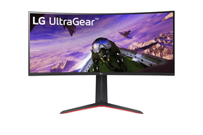 LG 34GP63AP-B UltraWide Monitor előlnézetben talpon. A kijelzőn egy pilóta és vadászgépek repülnek, lg ultrawide logóval.