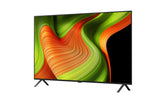 LG 48B5 OLED Televízió előlnézetben, talpon. A kijelzőn zöldés sárga absztrakt ábra.